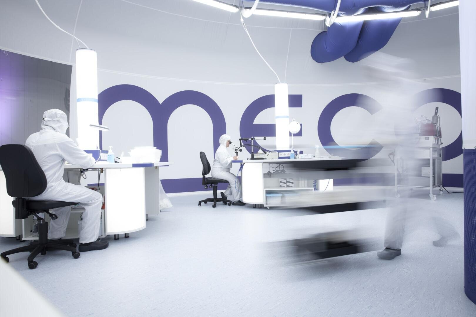 People in a cleanroom sitting at tables manufacturing medical technology products