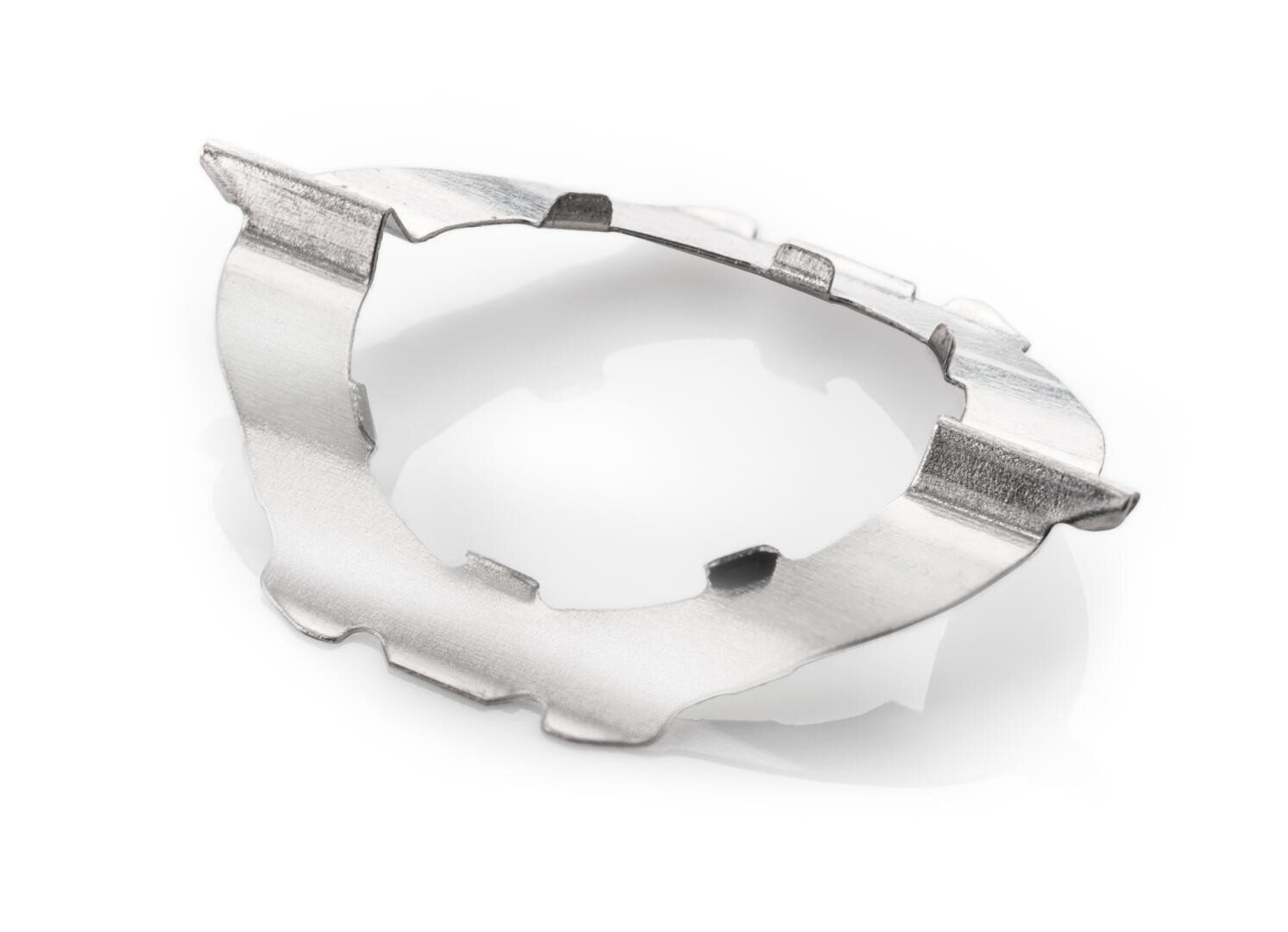 A thin, silver, irregularly shaped metal component with notches and cutouts, photographed on a white background.