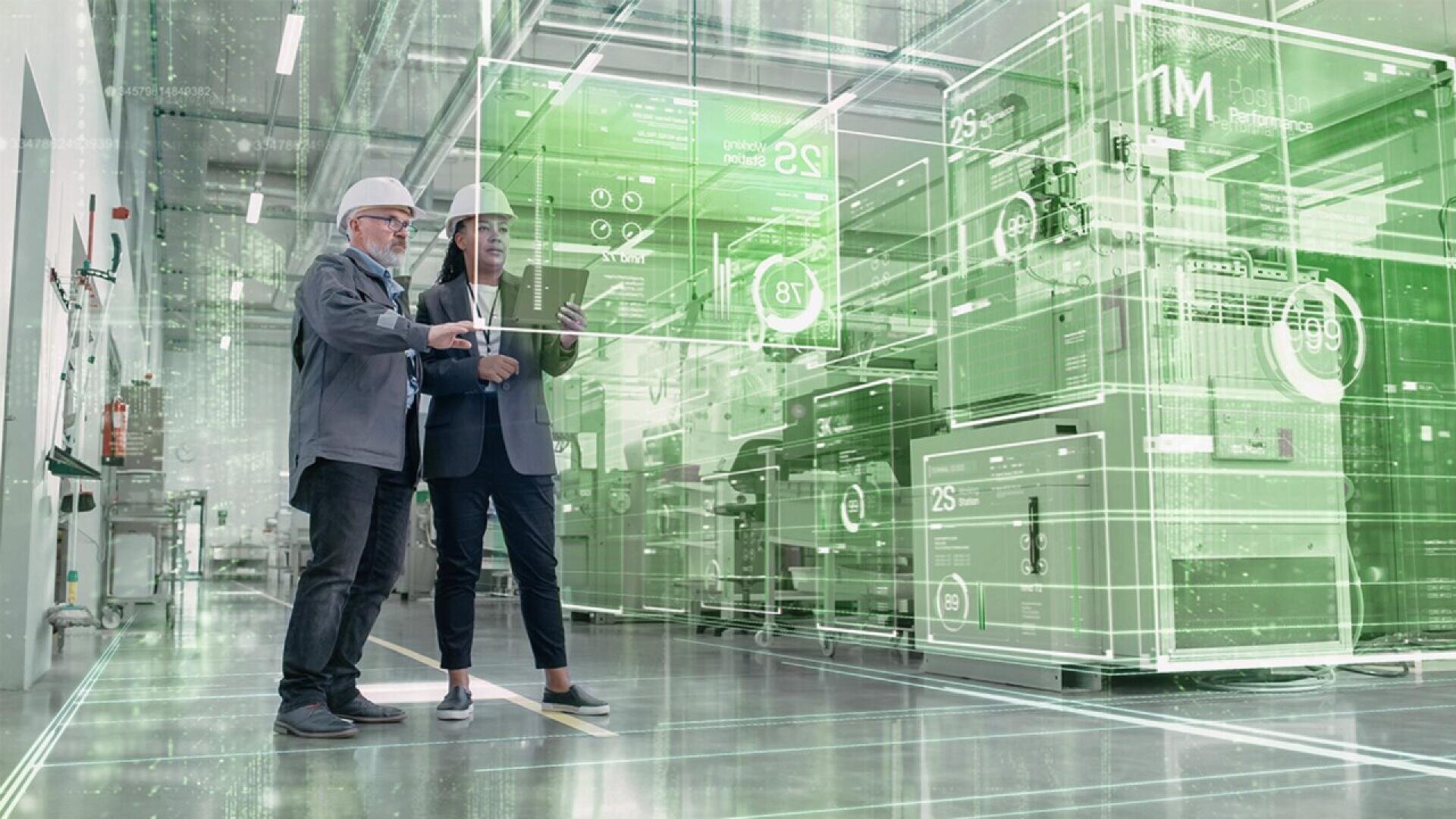Two people in helmets stand in a modern factory, looking at a tablet. Digital green graphics overlay the image, displaying data and schematics, representing advanced technology and smart manufacturing.