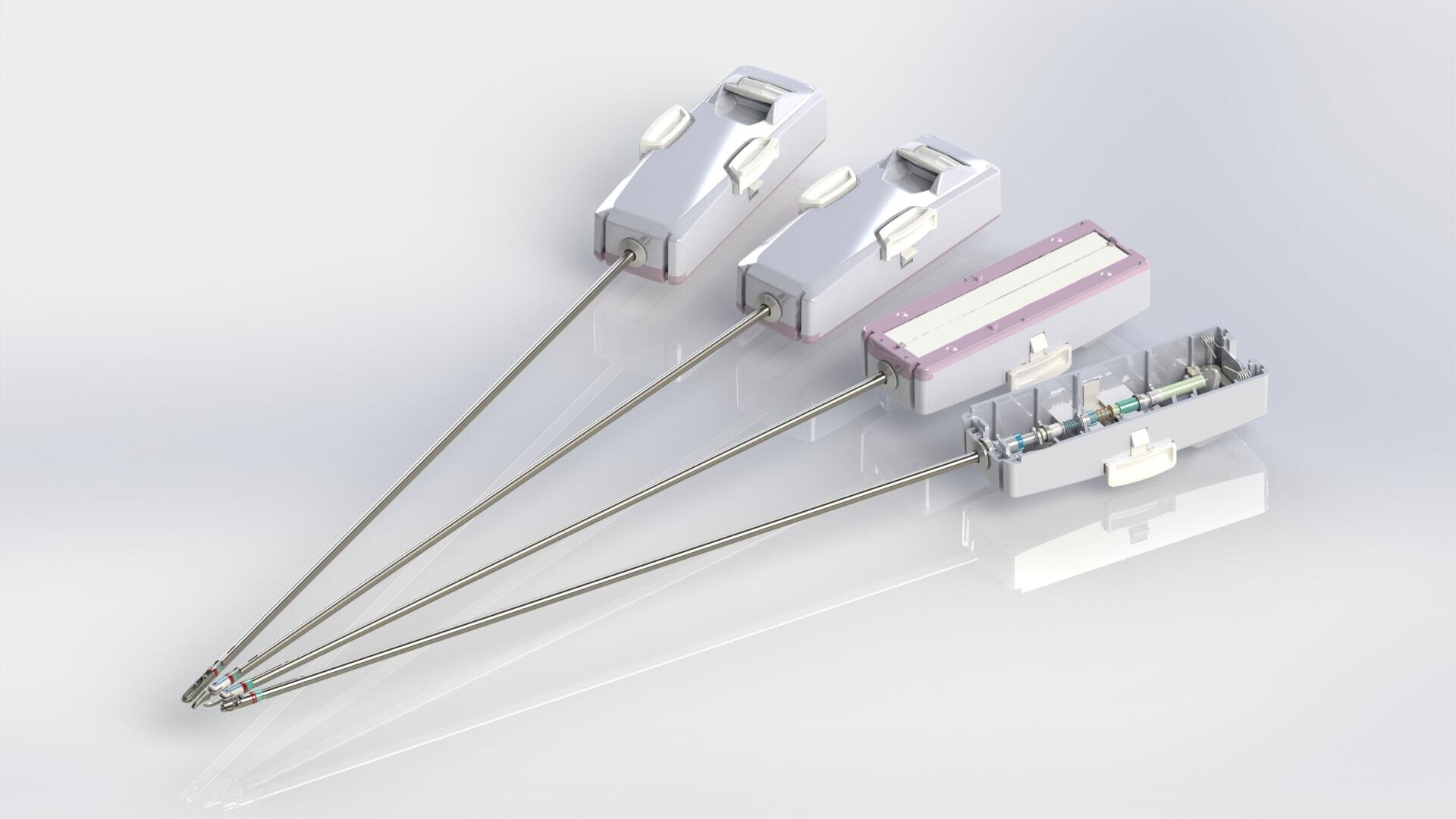 Drei medizinische Geräte mit langen Metallstäben und rechteckigen, weißen Kunststoffgriffen sind nebeneinander ausgestellt; das Gerät auf der rechten Seite hat ein teilweise transparentes Gehäuse, das den Blick auf die inneren Komponenten freigibt.