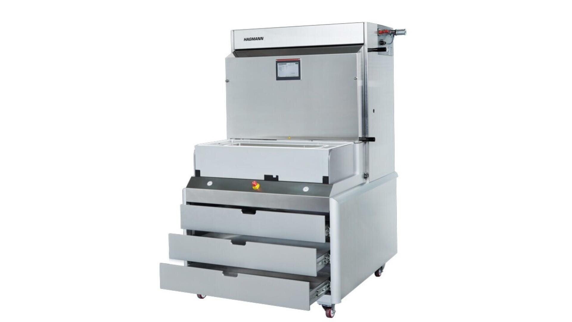 A large industrial stainless steel machine with a digital display, a top loading compartment, and two open drawers beneath on wheels, designed for commercial or industrial use.