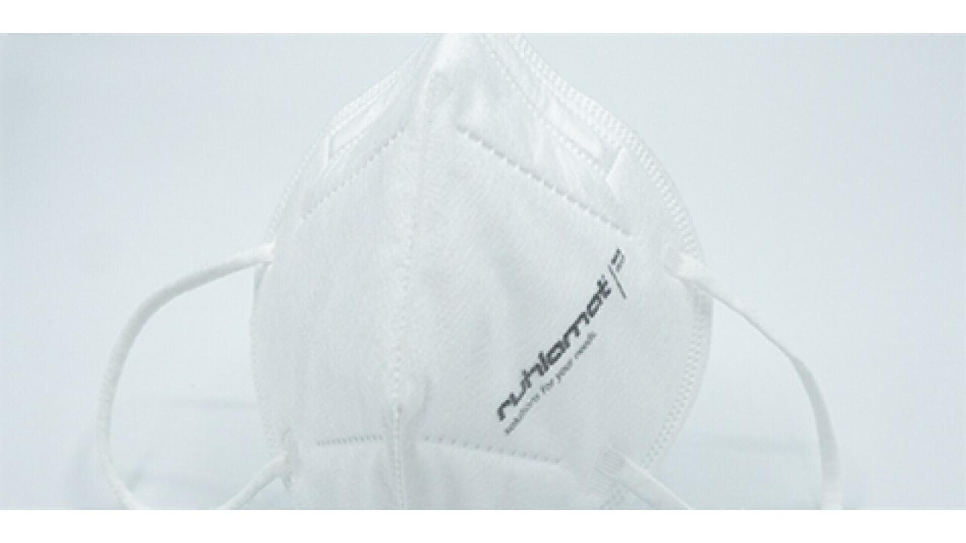 A white N95 respirator mask with ear loops, featuring text on the front, displayed against a plain white background.