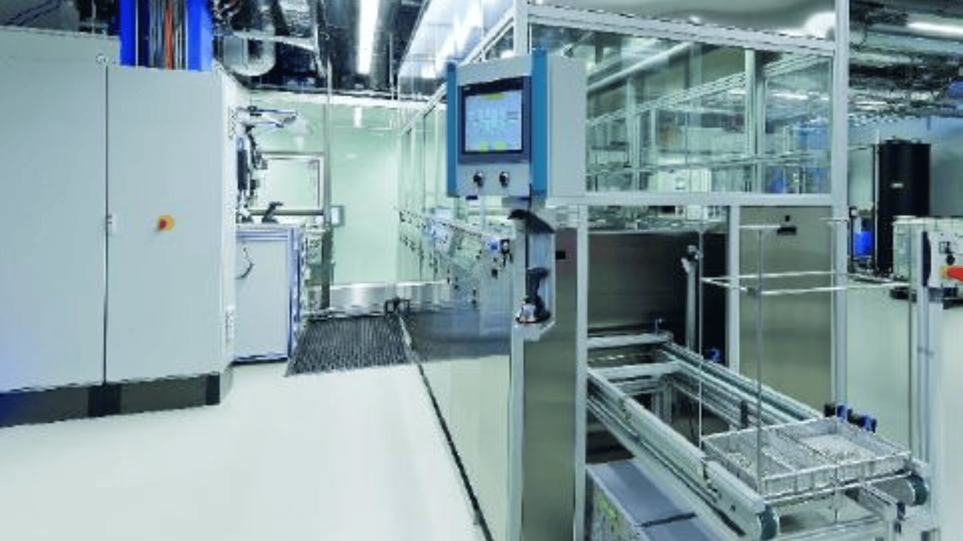 Modernes, sauberes Industrielabor mit Edelstahlgeräten, einem Bedienfeld mit Touchscreen, Glasgehäusen und heller Deckenbeleuchtung. Die Umgebung wirkt organisiert und steril.