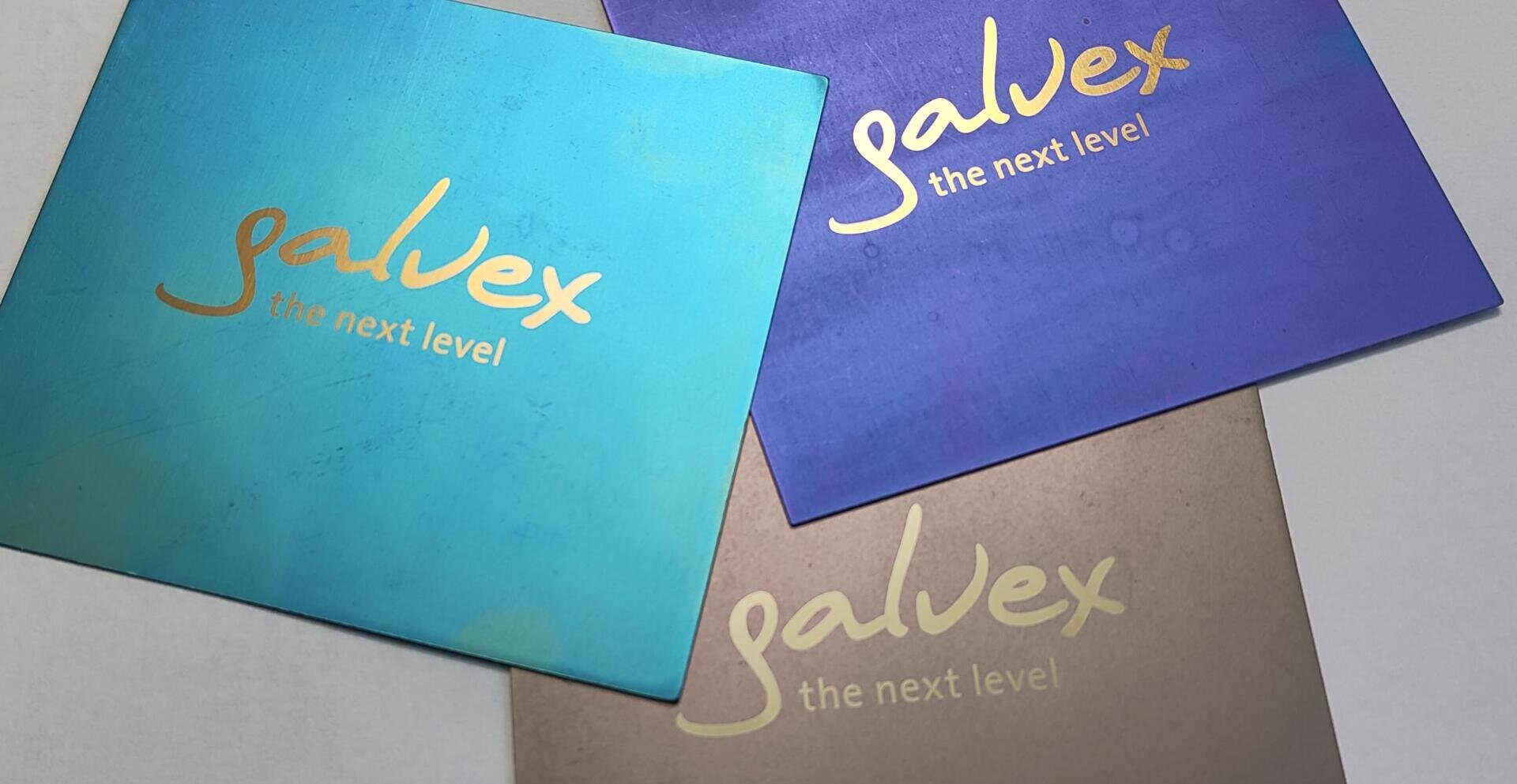 Three square cards in the colors teal, blue and bronze, each with the golden text galvex the next level in a handwritten font, slightly overlapping on a light surface.