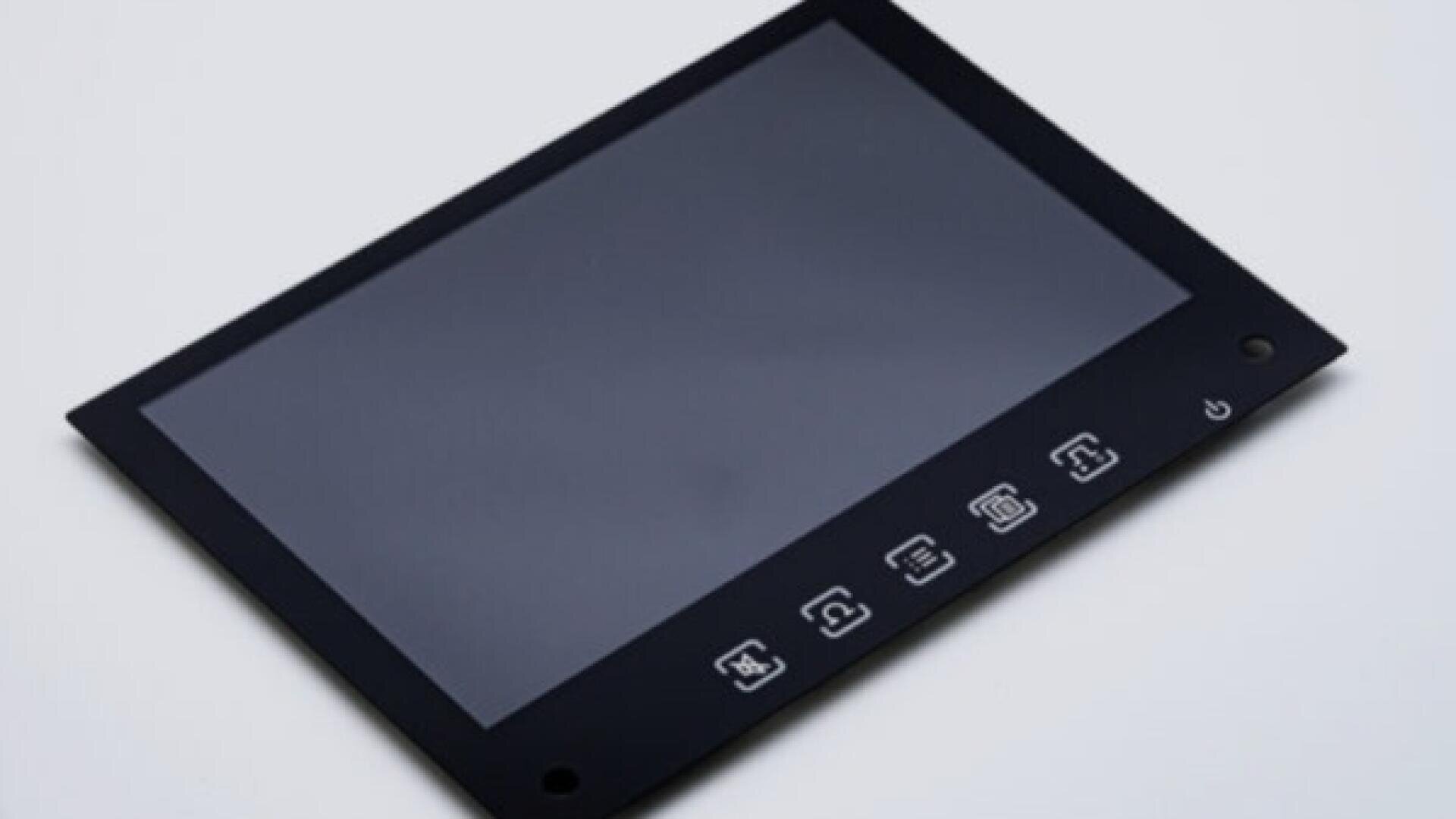 A flat, rectangular touchscreen device with five white icons and a power button at the bottom, displayed on a light gray surface.