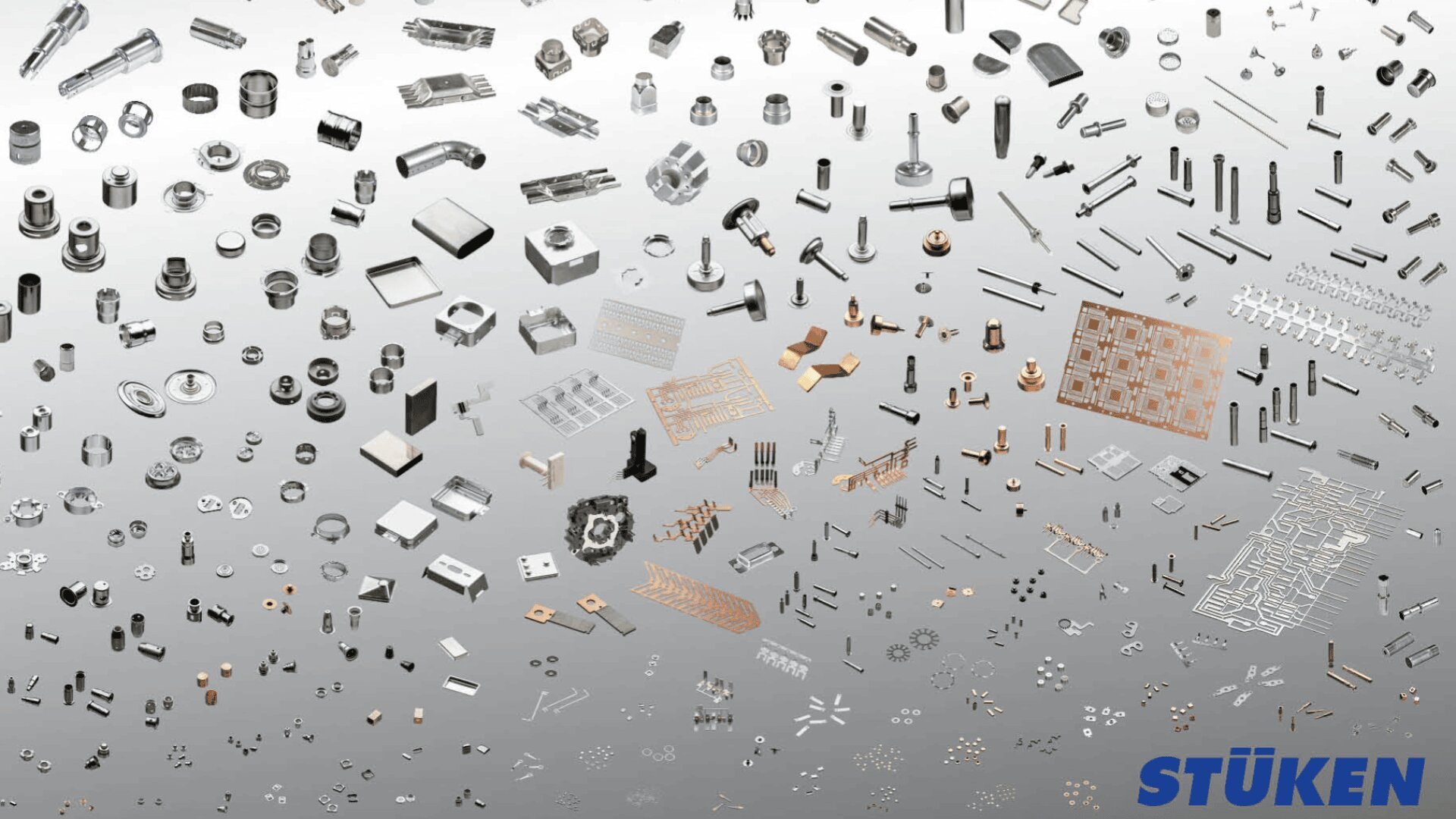 Hundreds of small metal components and parts, arranged by type and size, on a gray gradient background, with the blue STÜKEN logo in the bottom right corner.