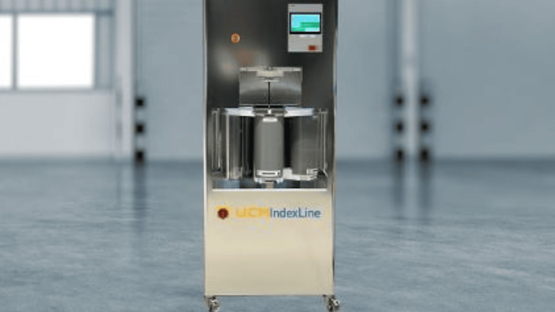 Eine Industriemaschine aus Edelstahl mit der Aufschrift WCN IndexLine steht auf Rädern in einem geräumigen, modernen und gut beleuchteten Raum mit großen Fenstern und einem glatten Boden. An der Vorderseite ist ein Touchscreen-Display angebracht.