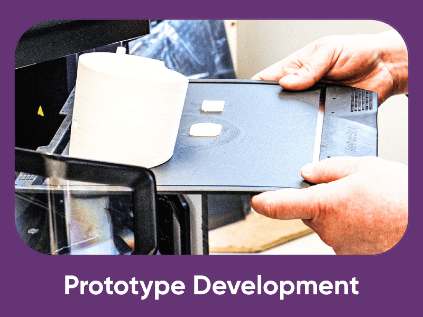 Eine Person entnimmt ein Tablett mit 3D-gedruckten Objekten aus einem 3D-Drucker und veranschaulicht damit den Prozess der Prototypenentwicklung. Die Szene ist lila umrandet, darunter steht "Prototypentwicklung".
