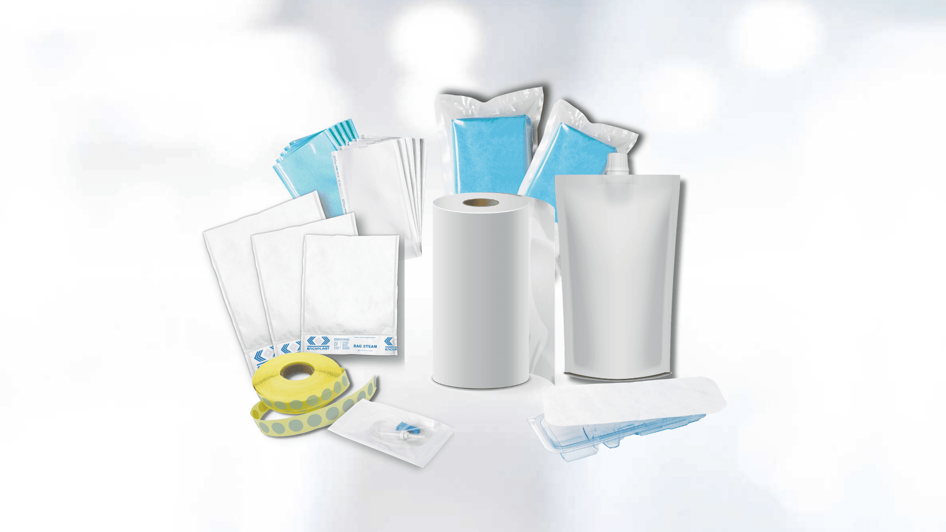 A collection of packaging and hygiene products, including paper rolls, sealed bags, adhesive tape, sachets of blue gel and clear plastic packaging, all displayed on a soft, blurred white background.