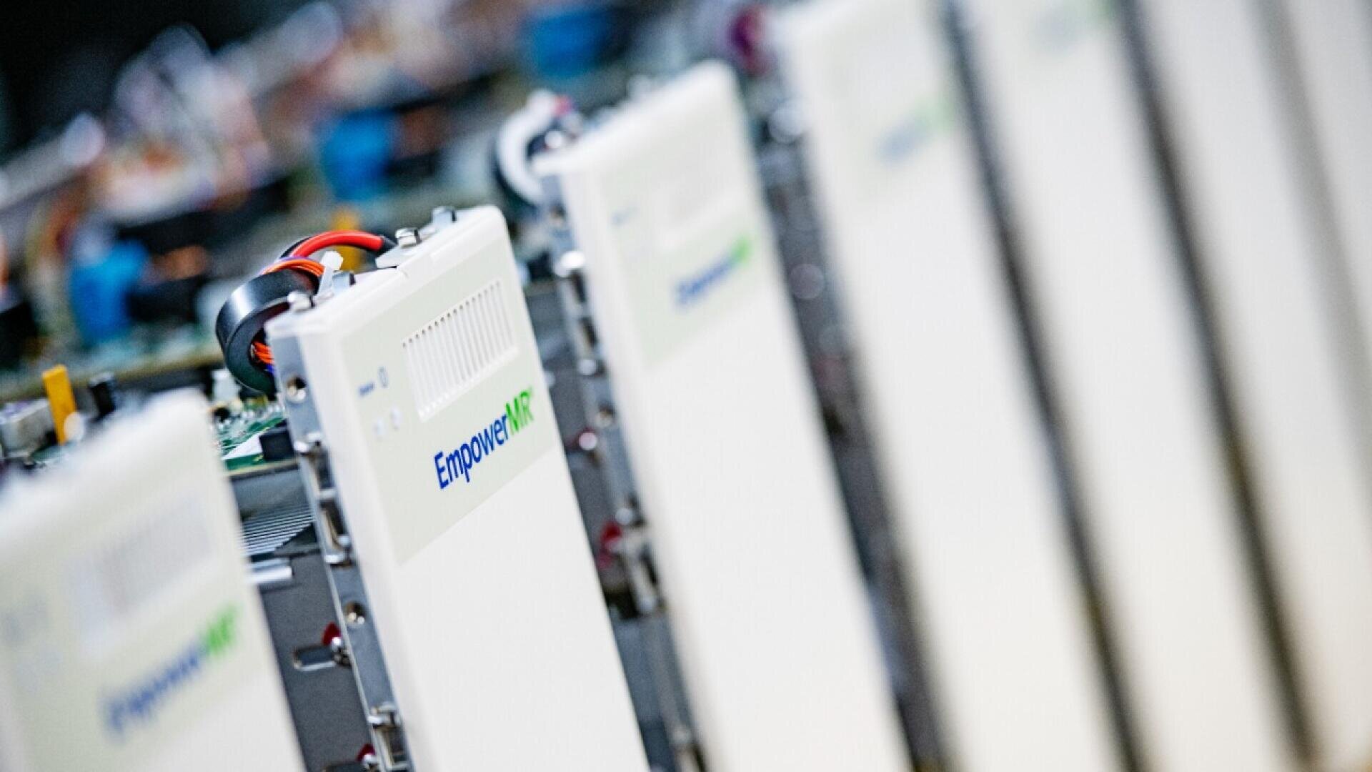 Close-up view of several white electronic server modules lined up in a row, with the label Empower visible on the front of the nearest unit. The background is blurred, highlighting the modules’ details.