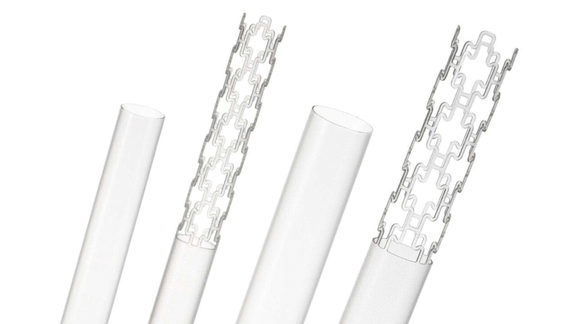 Four white cylindrical tubes are shown in a row. Each tube contains a metallic, expandable stent that is partially visible or emerging from the tube, illustrating the stent deployment process.