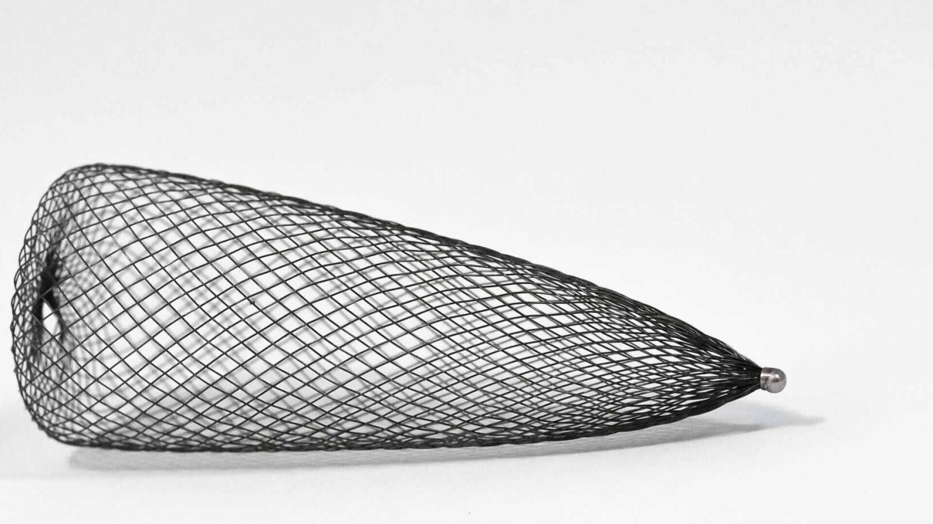 Ein schwarzer, kegelförmiger Maschenschlauch oder Filter liegt waagerecht auf einem einfarbig weißen Hintergrund, mit einer weiten kreisförmigen Öffnung auf der linken Seite und einem schmalen verjüngten Ende auf der rechten Seite.