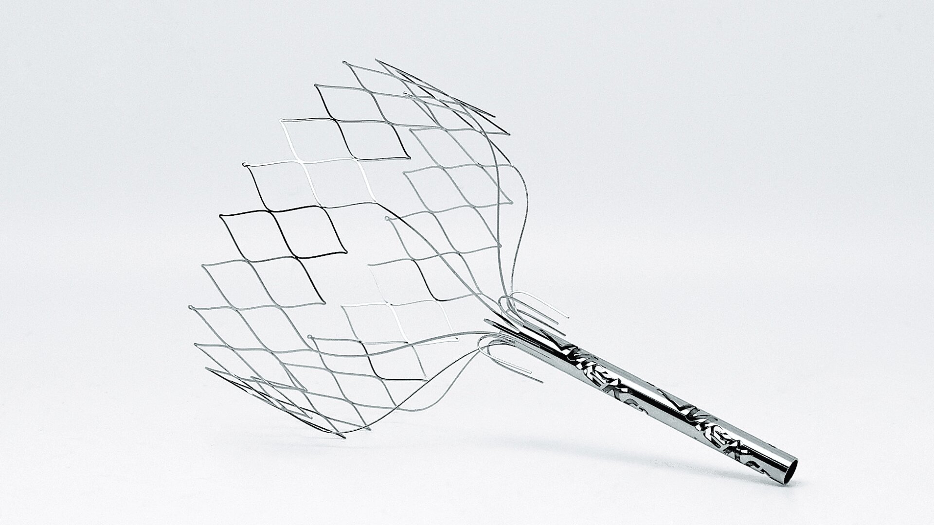 A metal wire scalp massager with a patterned handle and flexible wire prongs, positioned on a plain white background.