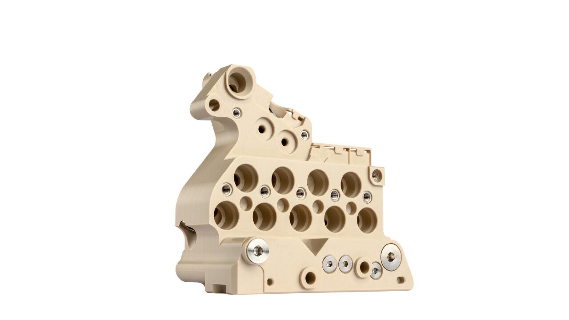 Beige-colored, complex plastic or polymer mechanical component with multiple circular holes and embedded metallic screws, shown against a white background.