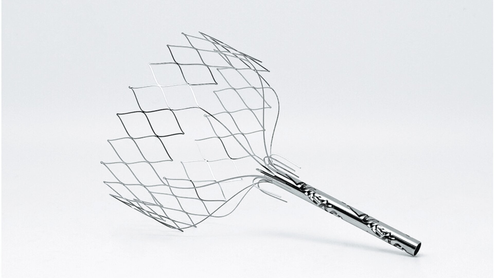Ein Kopfhautmassagegerät aus Metalldraht mit gemustertem Griff und flexiblen, rautenförmigen Drahtschlaufen, abgebildet vor einem schlichten weißen Hintergrund.