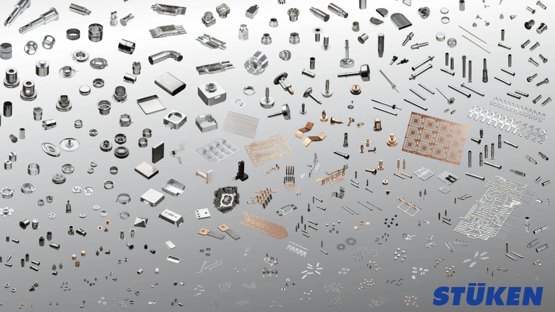Hunderte von kleinen Metallkomponenten und -teilen, geordnet nach Art und Größe, auf einem grauen Hintergrund mit Farbverlauf, mit dem blauen STÜKEN-Logo in der rechten unteren Ecke.