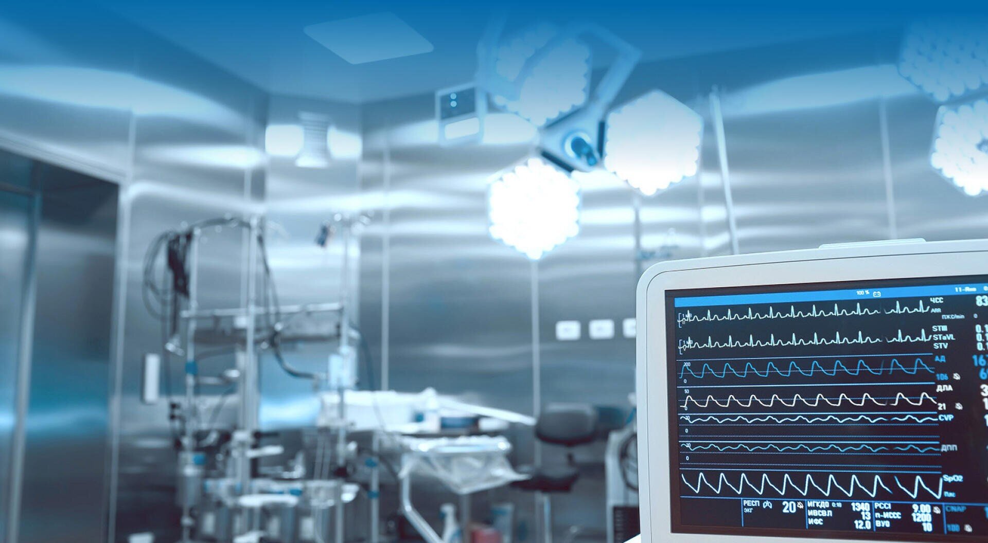 A modern hospital operating room with surgical equipment and bright lights, featuring a close-up of a monitor displaying patient vital signs. The environment appears clean and sterile.