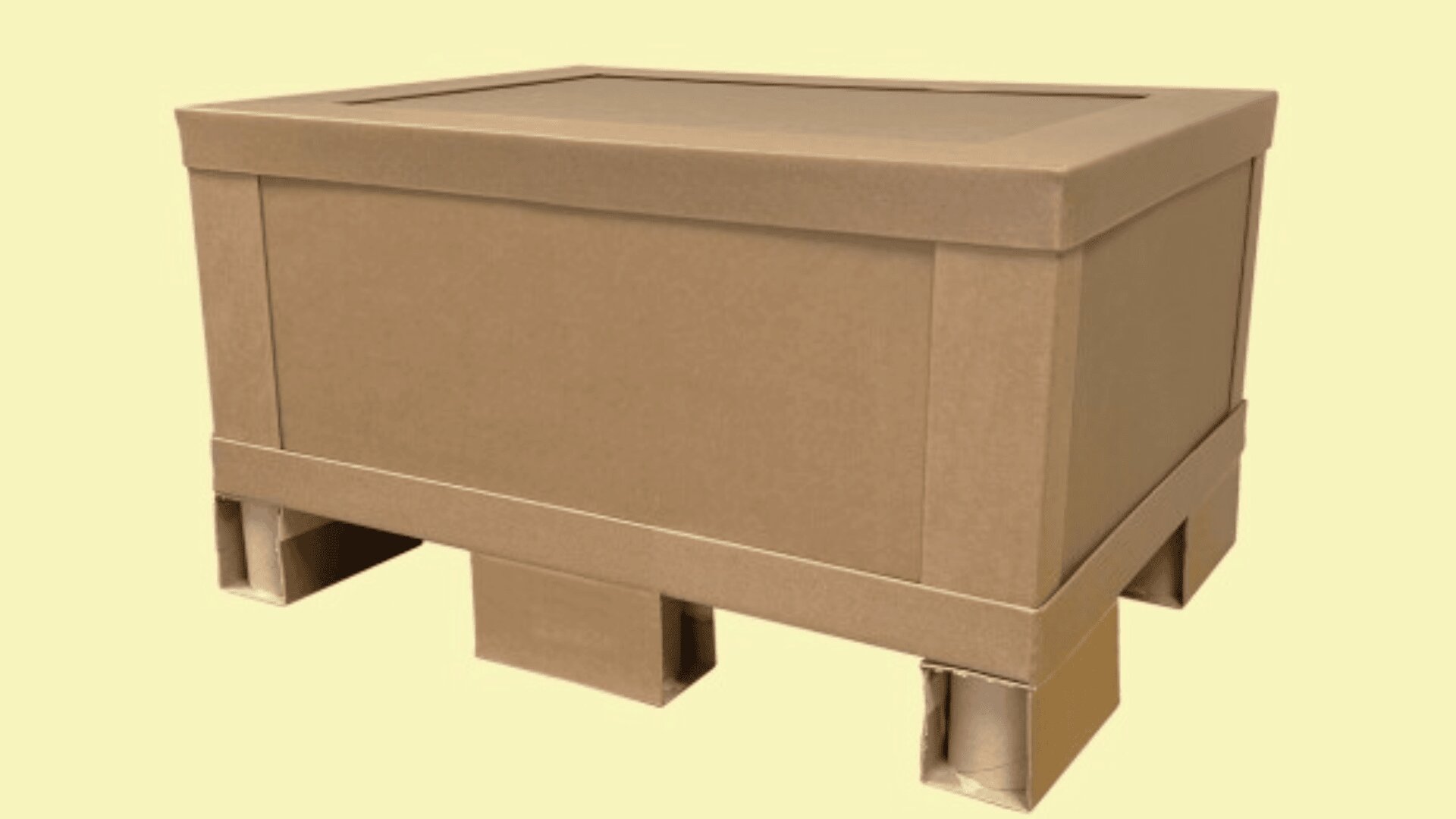 A large, rectangular cardboard box with a fitted lid sits on a matching cardboard pallet against a plain light yellow background.