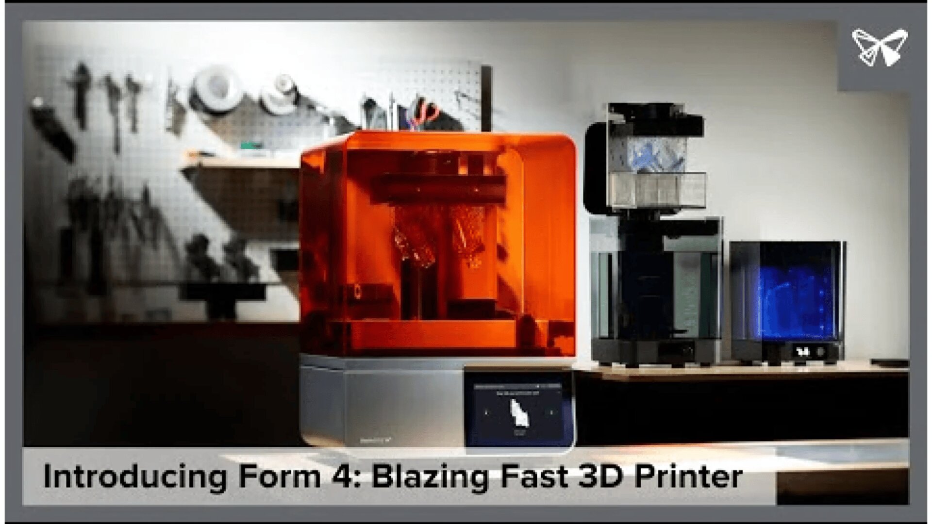 A sleek orange 3D printer, labeled Form 4, sits on a table next to two other 3D printers with blue-lit interiors. Tools hang on a pegboard in the blurred background. Text reads: Introducing Form 4: Blazing Fast 3D Printer.