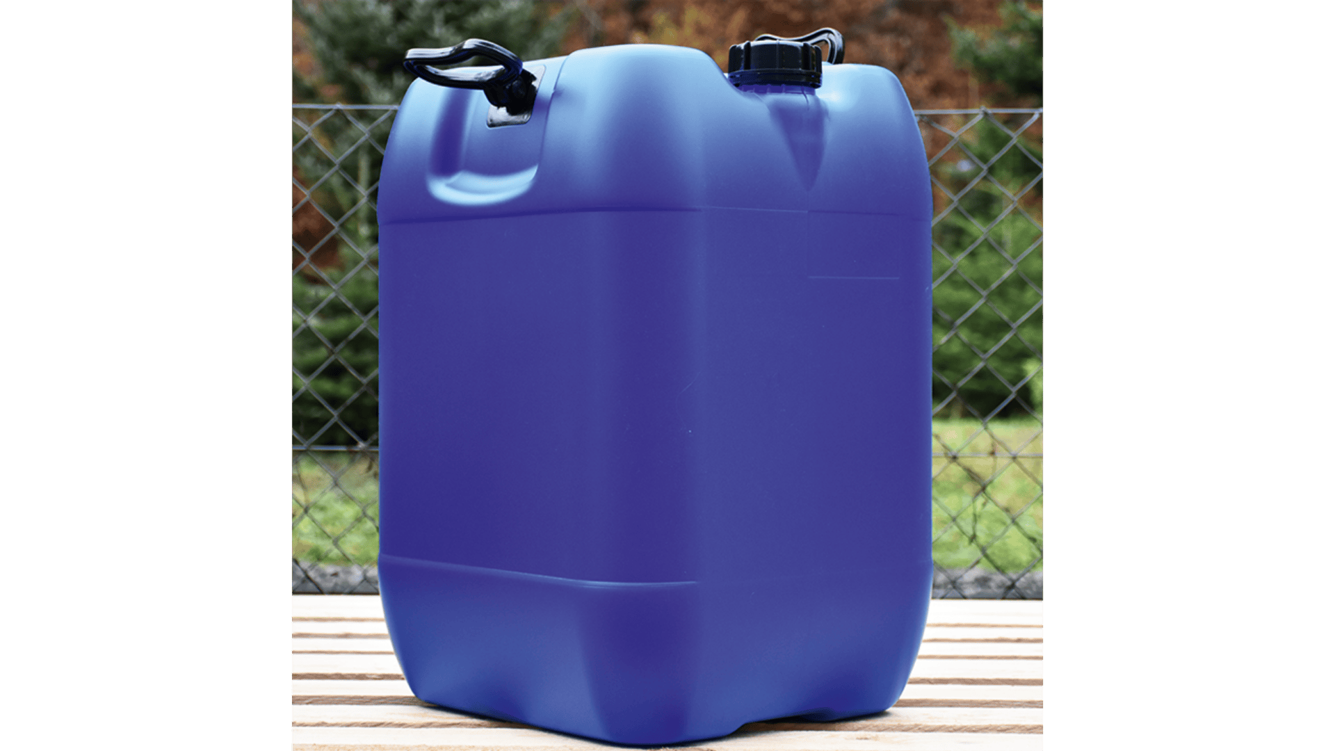 Ein großer blauer Plastikkanister mit schwarzem Deckel steht auf einer Holzfläche im Freien, mit einem Metalldrahtzaun und grünen Bäumen im Hintergrund.