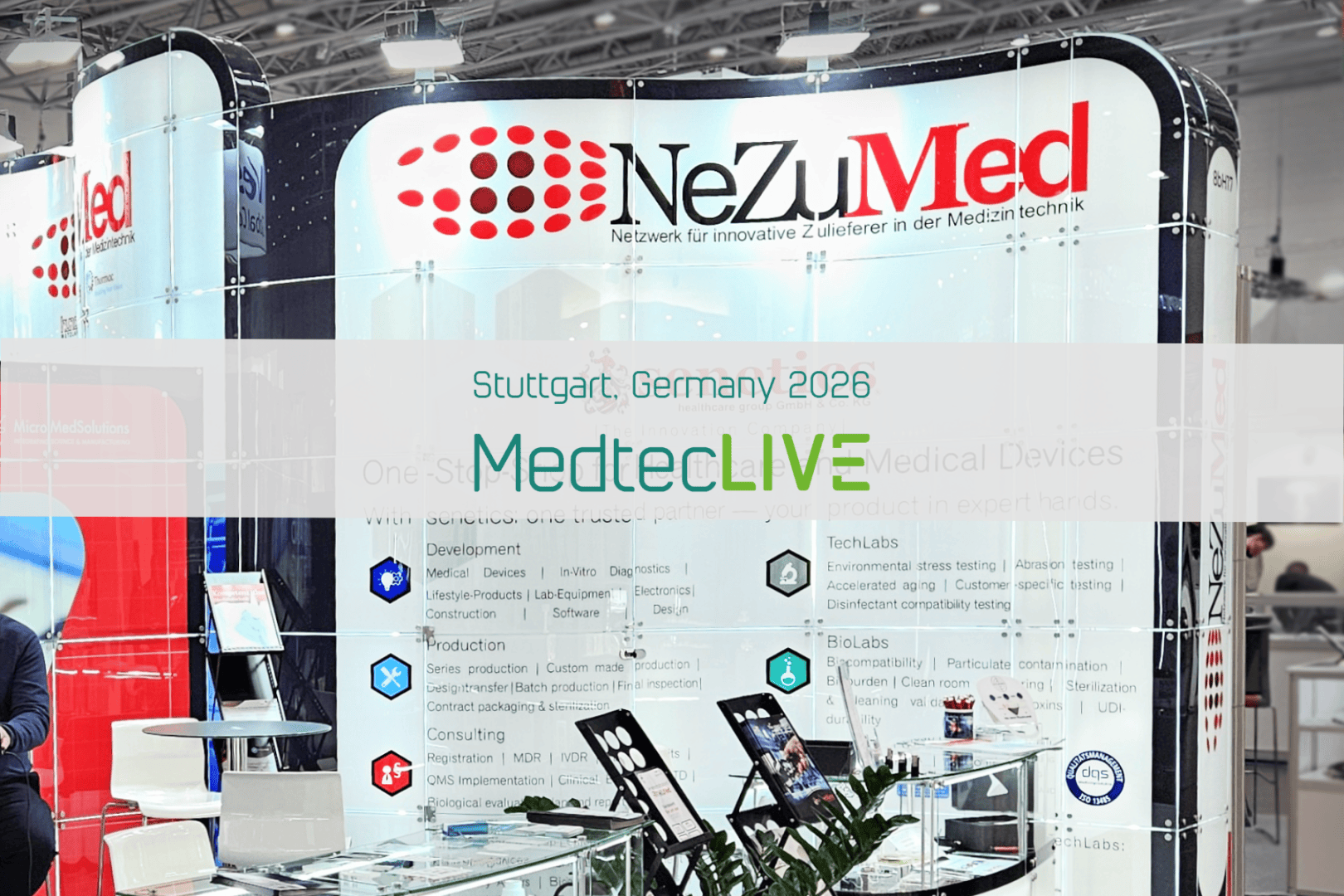 Messestand von NeZuMed auf einer Fachmesse, mit Beschilderung in Deutsch und Englisch und einem Banner mit der Aufschrift Stuttgart, Deutschland 2026 MedtecLIVE im Vordergrund. Verschiedene Broschüren und Displays sind auf dem Stand zu sehen.