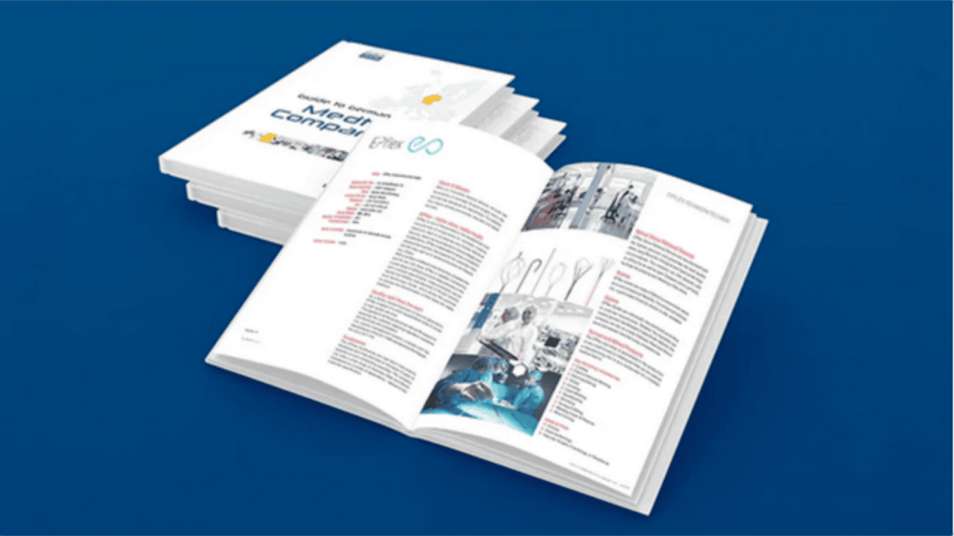 A stack of closed books and an open book displayed on a blue surface. The open book shows text, infographics, and images on its pages. The cover of the top closed book reads Media Compass.