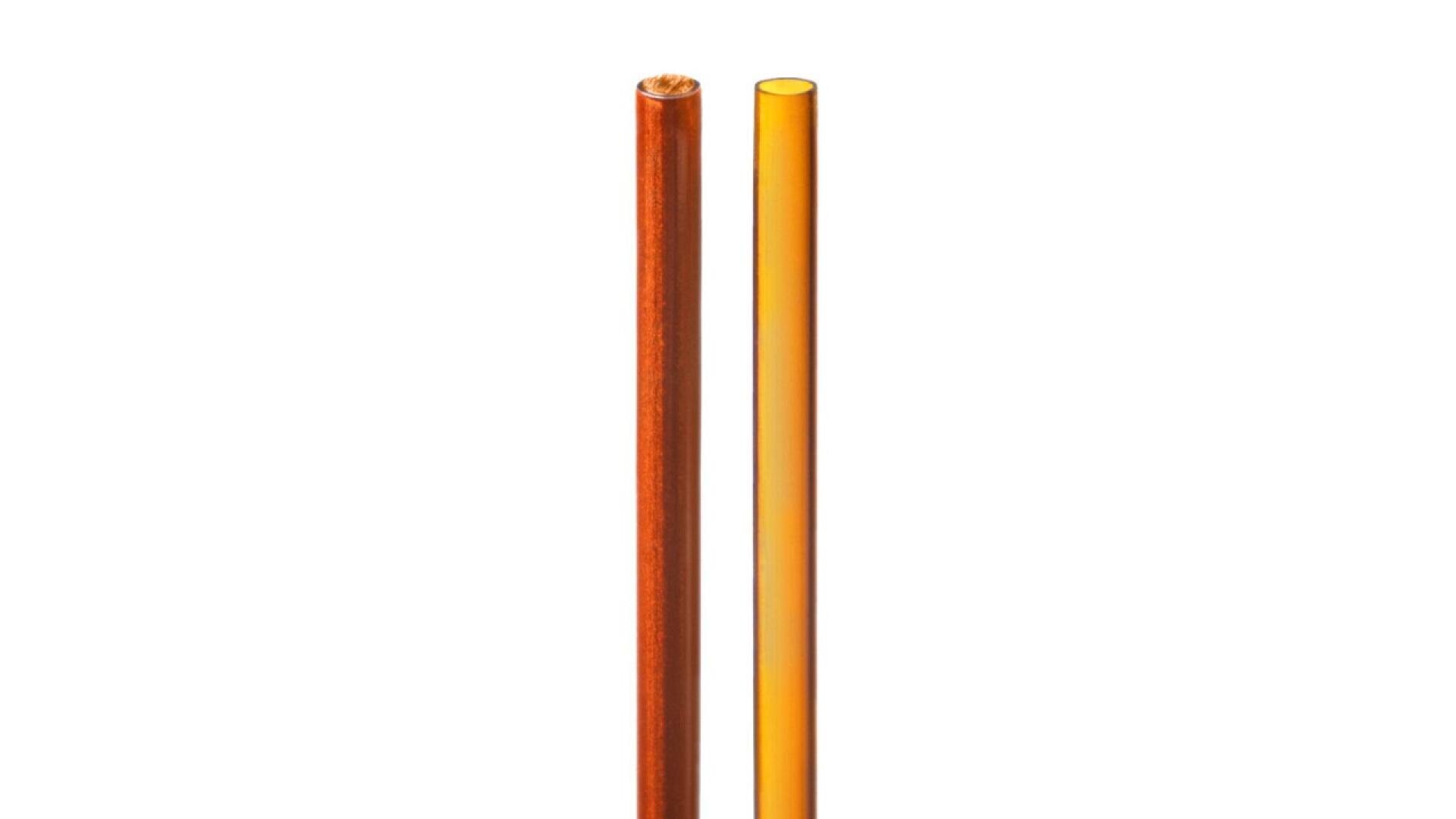 Two drinking straws, one brown and one orange, are standing upright side by side against a plain white background.