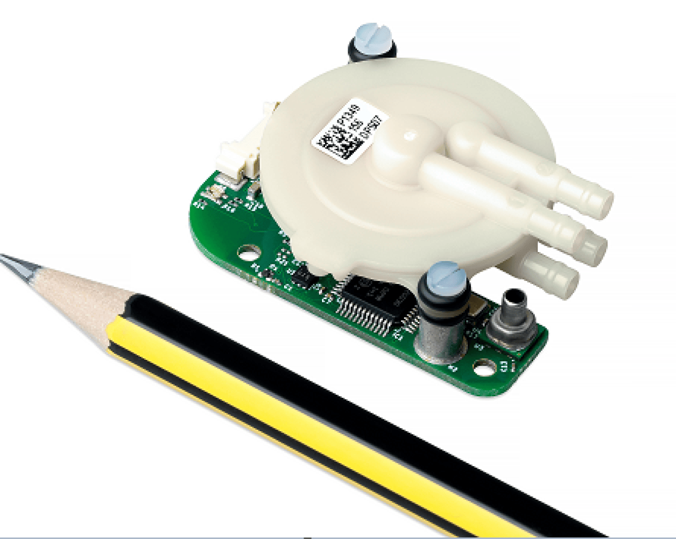 A small electronic sensor with a circular white plastic component and three nozzles is shown next to a sharpened black and yellow pencil for scale.