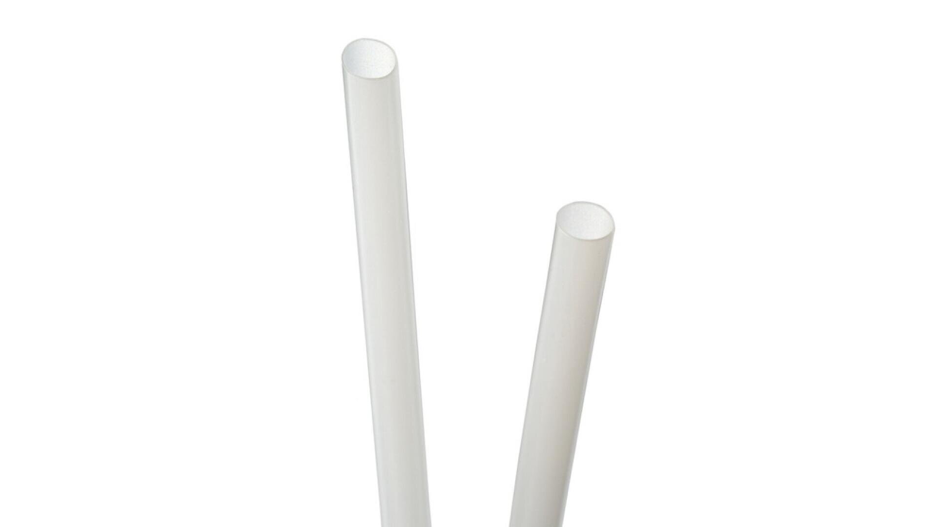 Two white cylindrical straws standing upright against a plain white background.