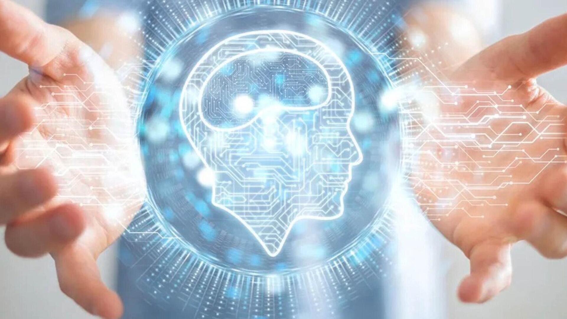 A person holds their hands open around a glowing digital illustration of a human head and brain, surrounded by abstract circuits and technology patterns, symbolizing artificial intelligence or futuristic technology.