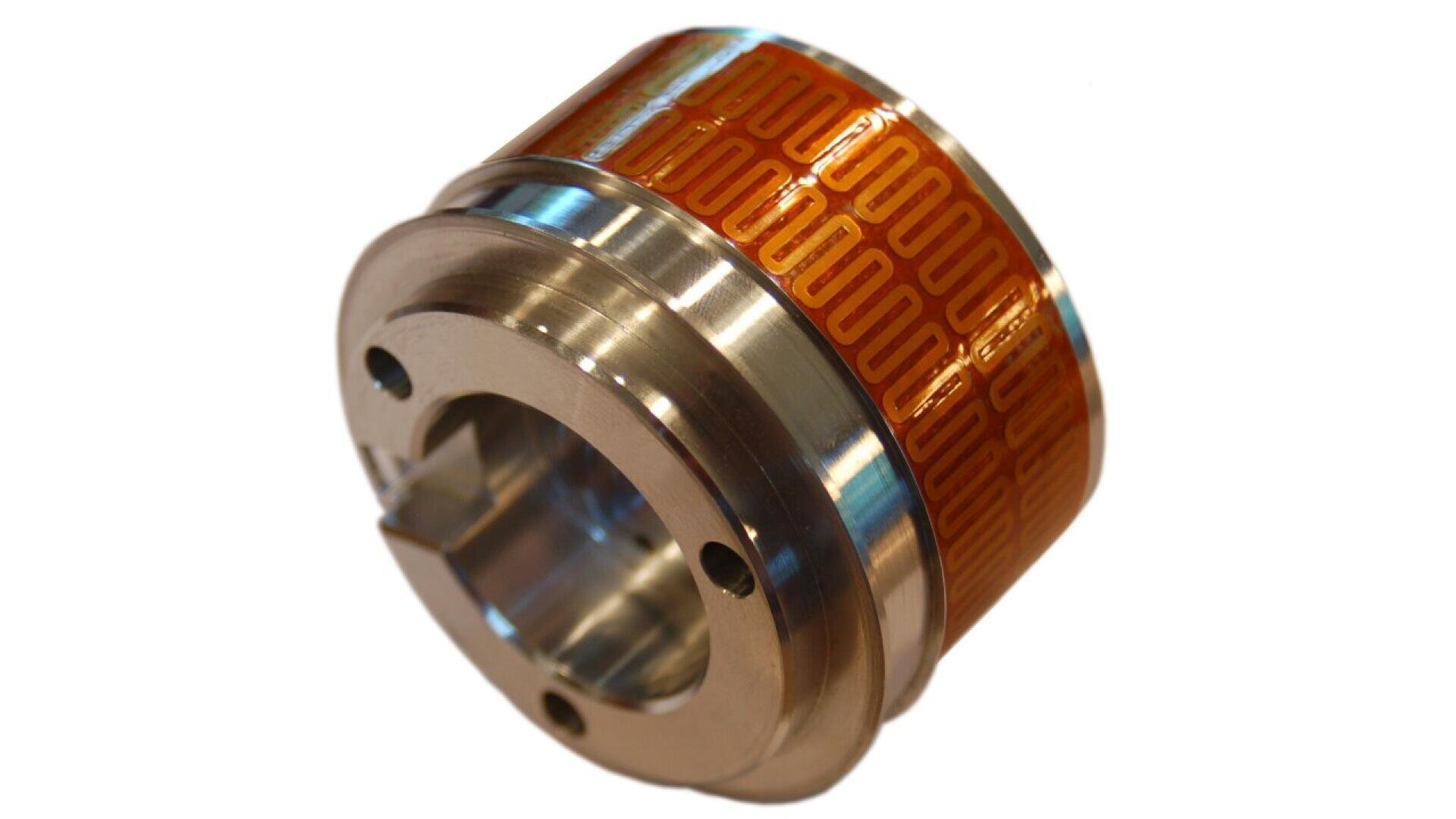 Ein zylindrisches Metallbauteil, dessen Oberfläche teilweise mit einer gemusterten orange-gelben Folie umwickelt ist, mit mehreren Löchern und einer zentralen Öffnung, dargestellt auf weißem Hintergrund.