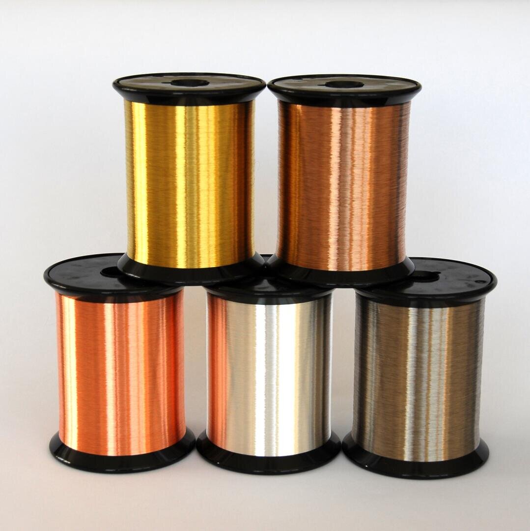 Five large spools of metallic wire in various colors (gold, copper, bronze, silver, and a darker shade) are arranged in a pyramid shape on a plain white background.