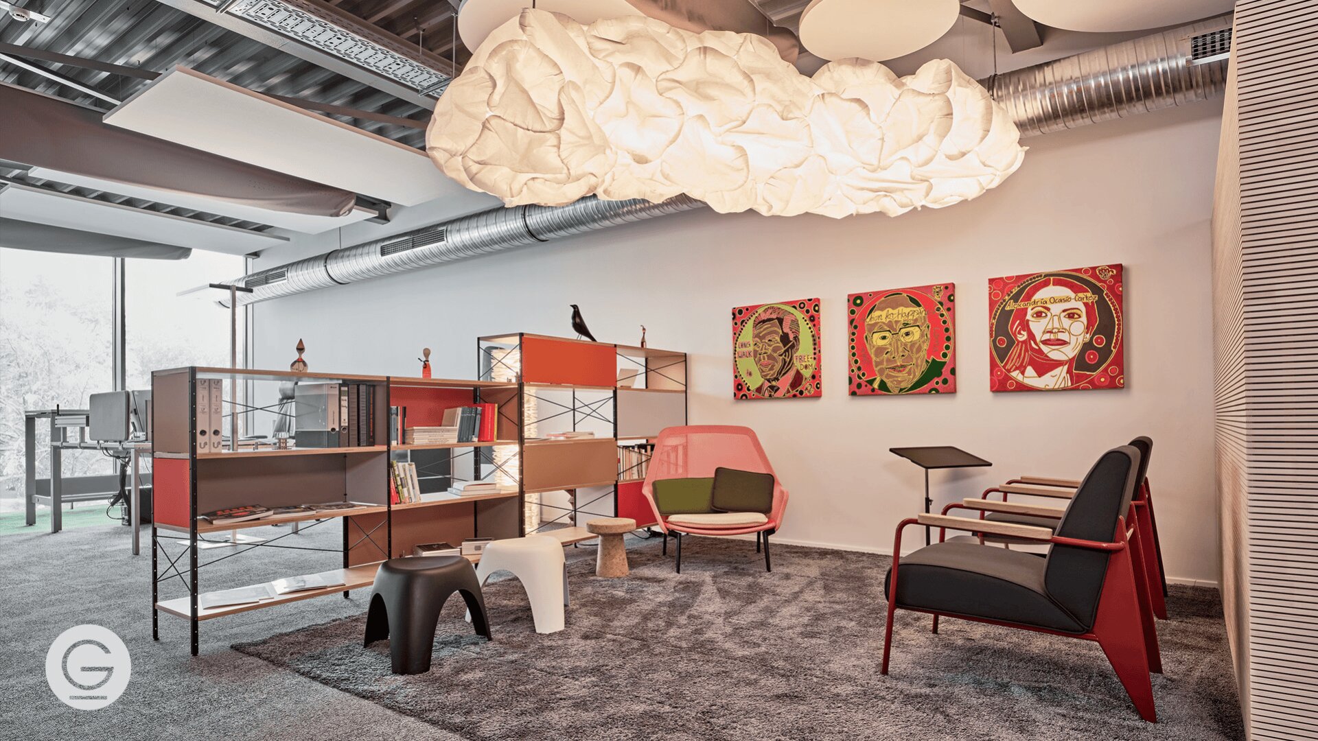Eine stilvolle, moderne Bürolounge mit farbenfrohen offenen Regalen, eklektischen Stühlen, einer großen wolkenartigen Deckenleuchte, drei lebendigen Porträtgemälden an der Wand und einem grauen Teppich auf einem glatten Boden.
