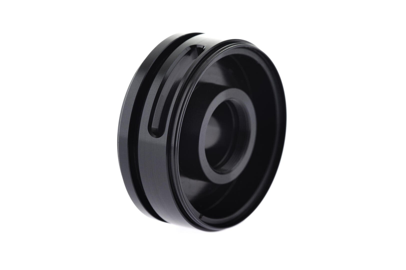 A black, cylindrical metal component with grooves and a central opening, photographed against a white background. The object appears to be a mechanical or automotive part.