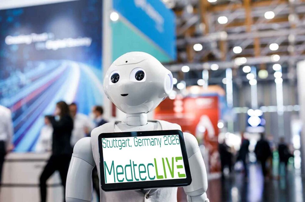 Ein humanoider Roboter hält einen Bildschirm mit der Aufschrift Stuttgart, Deutschland 2026 MedtecLIVE auf einer hell erleuchteten Messe, mit verschwommenen Menschen und Ständen im Hintergrund.