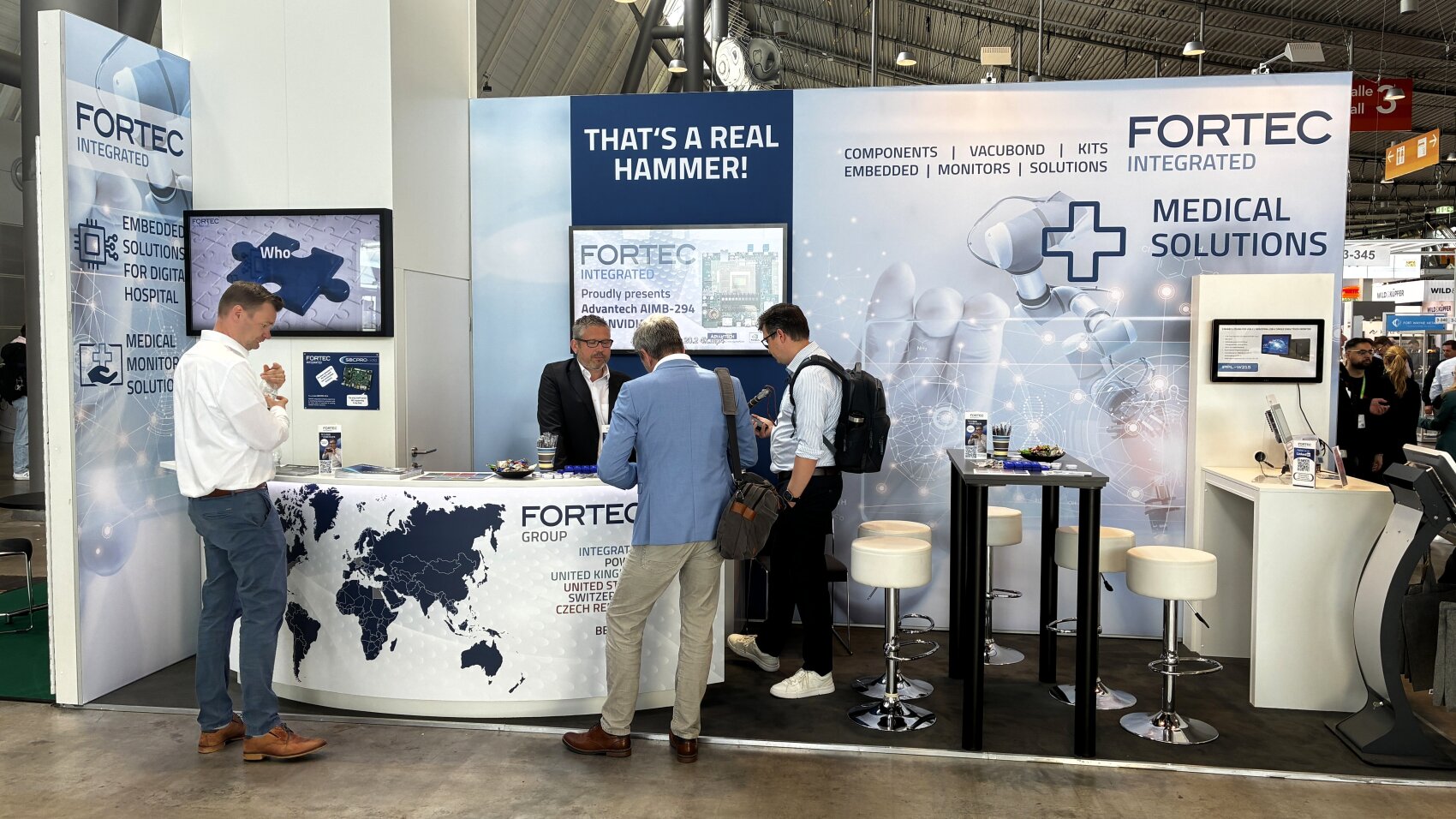 Fortec: Medizinmonitor mit Face-ID, NFC und All-in-One-Kabel  Ein 15,6-Zoll-Full-HD-Display, welches ursprünglich für einen großen Medizinkunden entwickelt wurde und nun auch am freien Markt erhältlich ist – mit diesem Highlight präsentierte sich der Display- und Systemintegrator Fortec Integrated auf der MedtecLIVE 2026. Der MED-Line 15.6 kombiniert auf rund 3,5 Zentimeter Bautiefe ein PCAP-Touchpanel mit 10-Punkt-Touch, IP65-versiegelter Glasfront und 500 cd/m² Helligkeit für den »rund um die Uhr-Klinikeinsatz.  Sicherheit ohne Handberührung  Der Monitor ist speziell auf die Zugangssicherheit im klinischen Alltag ausgelegt: Zur Authentifizierung stehen ein integrierter NFC-Reader sowie eine Kamera mit Face-ID-Funktion zur Verfügung. Im OP-Saal, wo der Arzt bereits sterile Handschuhe trägt, genügt die Gesichtserkennung zur Anmeldung – Patientendaten erscheinen automatisch, ohne Toucheingabe. Ein Näherungssensor erkennt zusätzlich, wenn keine Person mehr vor dem Gerät steht, und schaltet die Anzeige selbstständig ab. Hergestellung und Bonding des Touch-Panel-PCs erfolgen direkt bei Fortec.  congatec-Modul als Rechenplattform  Als Computing-Kern ist ein congatec COM-Express-Module verbaut – kompakt, lüfterlos mit passivem Wärmeableitkonzept und auf Langzeitverfügbarkeit ausgelegt. Alternativ lässt sich der Monitor per Single-Cable-Solution über ein USB-C-Kabel an einen externen Edge-PC anbinden, das dann gleichzeitig Video, Daten und Power überträgt – alle drei Verbindungen über ein einziges Kabel. Die höhere externe Rechenleistung ist laut Fortec etwa dann relevant, wenn KI-gestützte Bildauswertung gefragt ist: Ein möglicher Anwendungsfall ist die endoskopische Krebsfrüherkennung, bei der eine KI-Software Gewebeaufnahmen in Echtzeit klassifiziert und den Arzt auf auffällige Befunde hinweist.